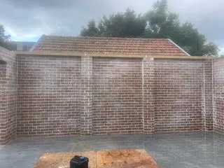 Brick garage wall with staining visible across the face brickwork