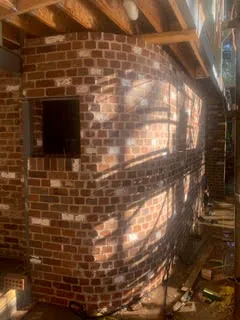 Internal brickwork under construction with exposed timber roof framing