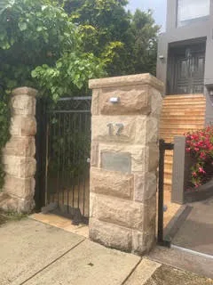 Sandstone gate piers at the frontage of a modern home