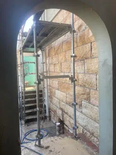 The same sandstone archway after low pressure cleaning, with the natural stone colour visible again