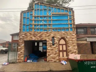The same house after brick cleaning, with the brickwork and arched entry clean and the mortar joints sharp