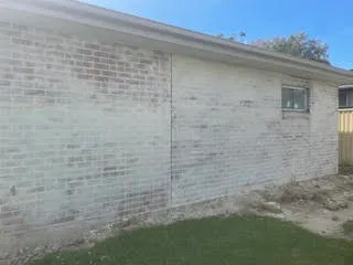 Painted rendered wall with grey weathering and staining