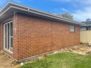 Red brick extension with clean brickwork under a blue sky